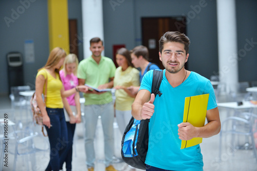 Portrait of a young student standing outside with friends in the background