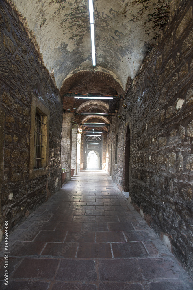 Old stone corridor with the door at the end
