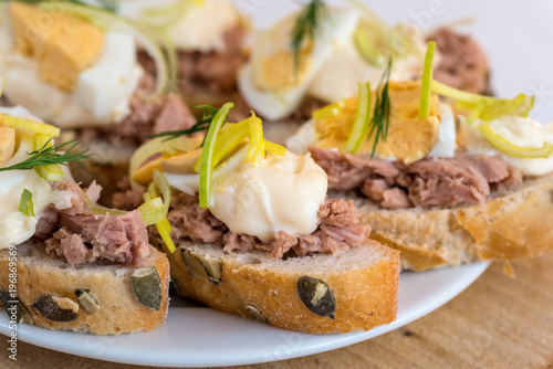 Bruschetta, snack sandwiches with tuna, egg and mayonnaise decorated by dill.