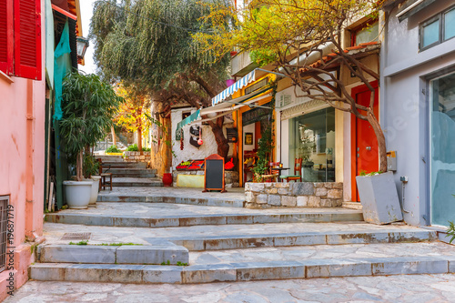 Beautiful cosy narrow street with stairs in famous Placa district, Old Town of Athens, Greece © Kavalenkava