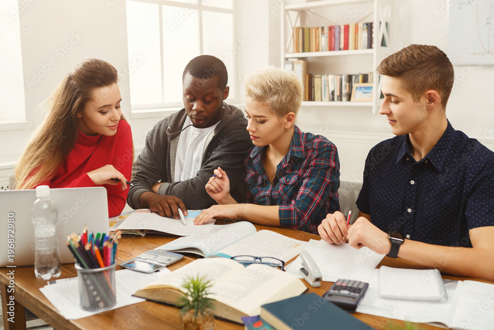 Group of diverse students studying at wooden table Group of diverse students studying at wooden table