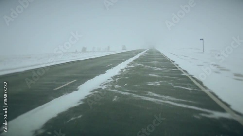 movement of the car forward on the snow-covered Siberian route in a stream of trucks, at squally lateral wind photo