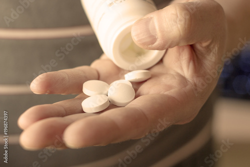 the bottle of pills in hand close up