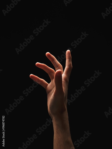 Male hand reaching something up, cutout on black