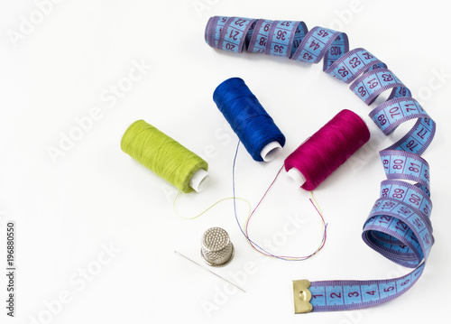 Sewing accessories and threads on white, top view