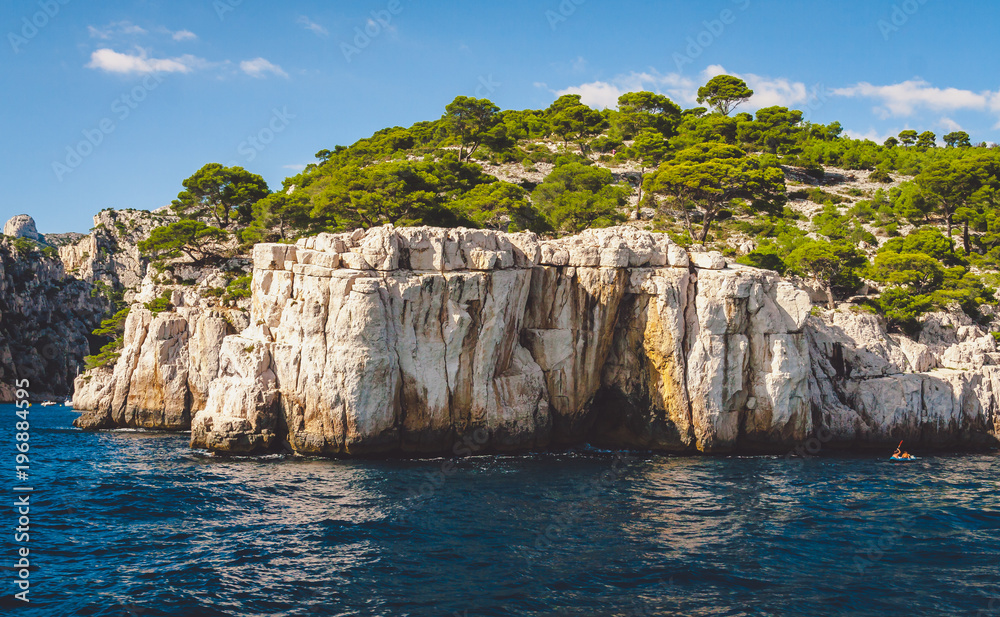 White cliffs of Massif des Calanques covered with lush pine trees in Cassis near Marseille, France