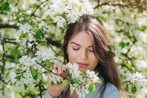 Woman near blooming apple tree