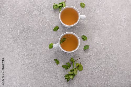 Cups of aromatic tea with mint on table