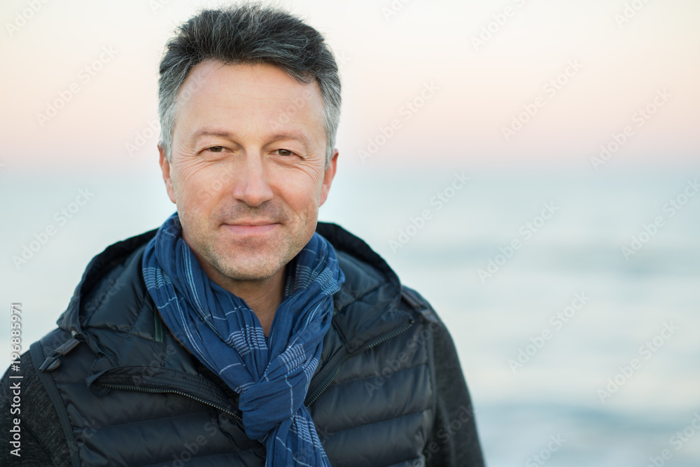 Handsome middle-aged man at the beach. Attractive happy smiling mid adult male model posing at seaside, sunset o sunrise. Outdoor portrait of beautiful man. Handsome middle-aged man at the beach. Attractive happy smiling mid adult male model posing at seaside, sunset o sunrise. Outdoor portrait of beautiful man.