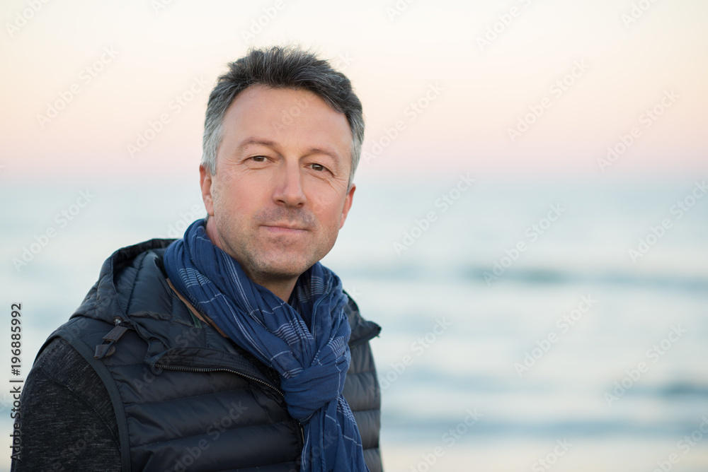 Handsome middle-aged man at the beach. Attractive happy smiling mid adult male model posing at seaside, sunset o sunrise. Outdoor portrait of beautiful man. Handsome middle-aged man at the beach. Attractive happy smiling mid adult male model posing at seaside, sunset o sunrise. Outdoor portrait of beautiful man.