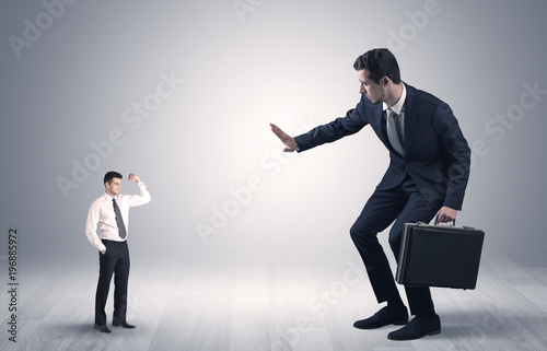 Giant businessman scared of small businessman