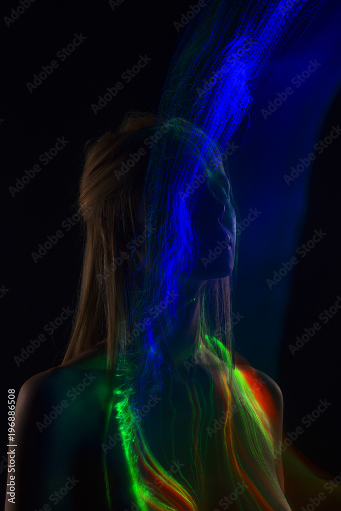 Conceptual avant-garde silhouette portrait of a beautiful blonde girl covered with multicolored lines applied by a lightbrush Conceptual avant-garde silhouette portrait of a beautiful blonde girl covered with multicolored lines applied by a lightbrush