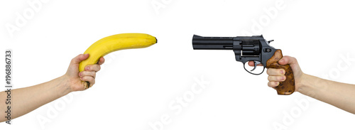 hand with a banana and a hand with gun isolated on white