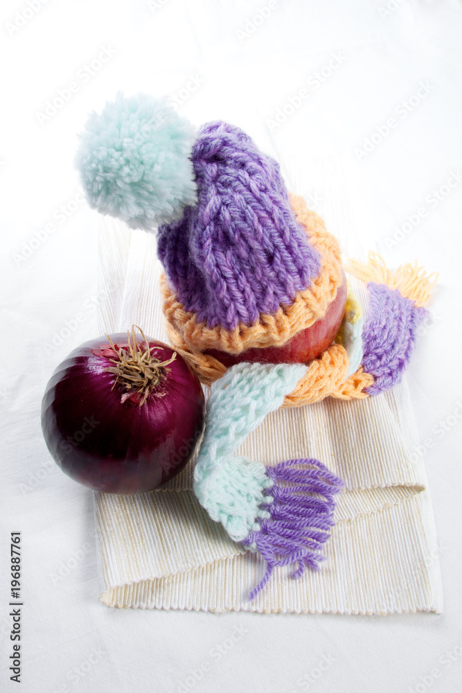 Concept of flu sick person with cap and scarf with healthy tea, fruit and vegetable