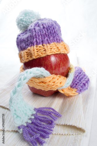 Concept of flu sick person with cap and scarf with healthy tea, fruit and vegetable