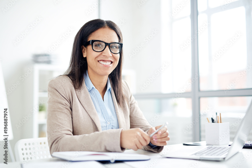 Portrait of happy businesswoman sitting at the table at office Portrait of happy businesswoman sitting at the table at office