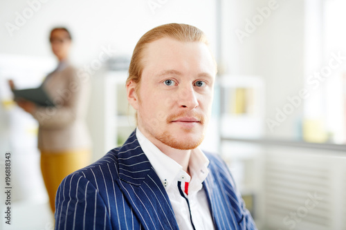 Portrait of redheaded businessman in suit working at office