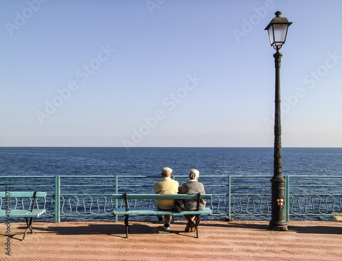 Rentner Paar am Meer auf Bank