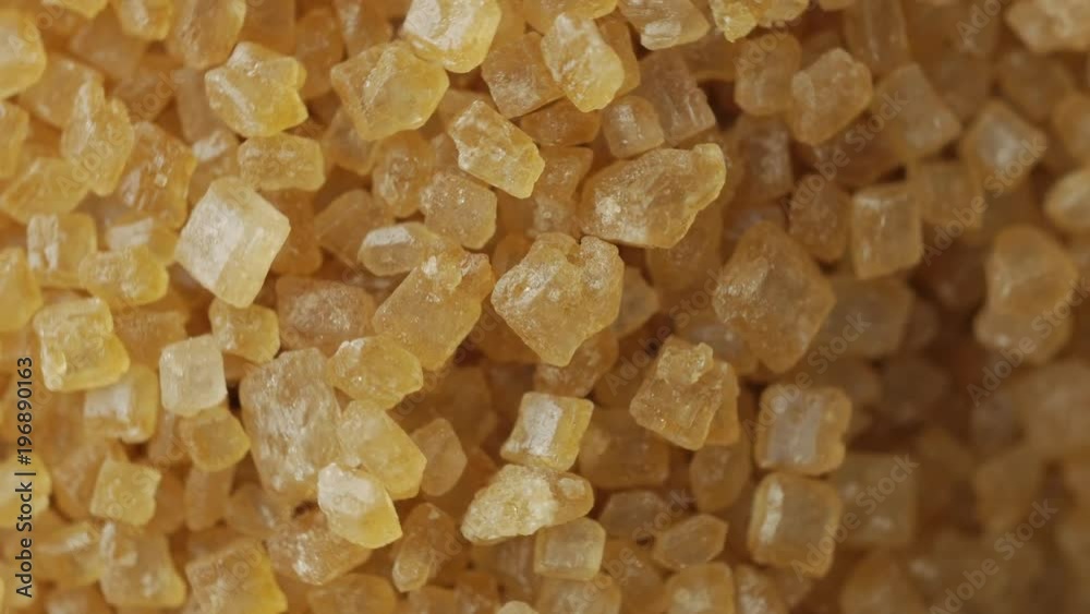 Brown sugar crystal from sugar cane,rotating. Macro shot, top view. Brown sugar crystal from sugar cane,rotating. Macro shot, top view.