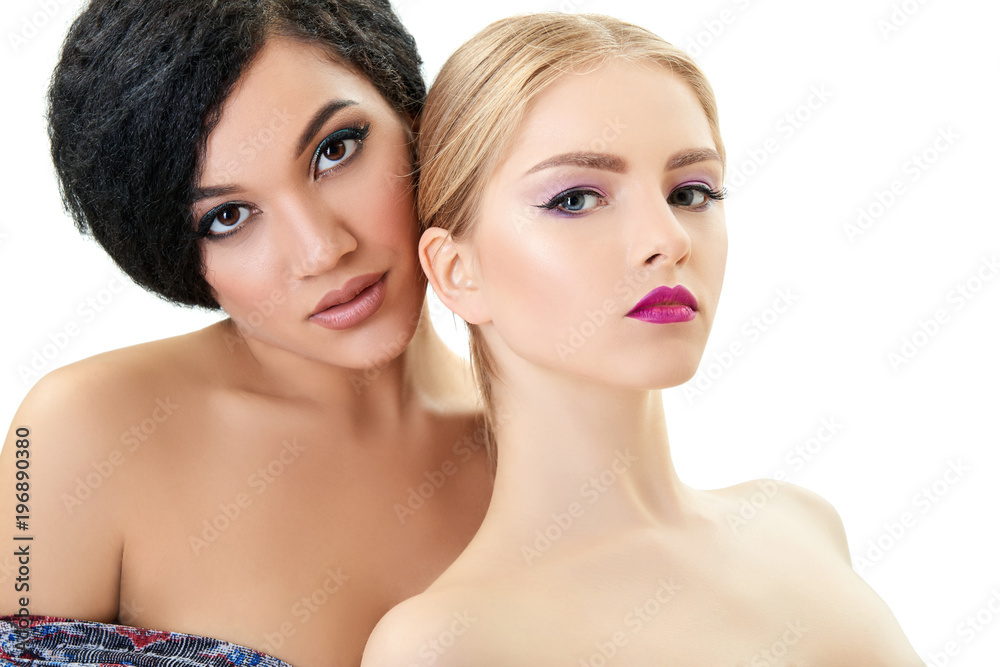Makeup. Double female portrait. Caucasian blond girl and beautiful young woman posing in studio over white background. Fashion, beauty, glam, youth.