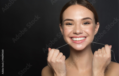 Fotografie, Tablou Portrait of positive young woman who is taking care of her teeth