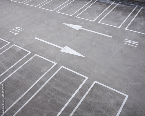 white lines of parking lots and arrows in dutch parking garage © ahavelaar
