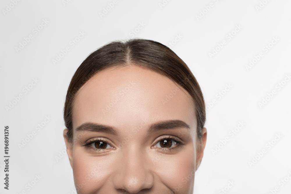 Happy look. Close-up of positive young woman with beautiful eyes are looking at camera with joy. Isolated background Happy look. Close-up of positive young woman with beautiful eyes are looking at camera with joy. Isolated background