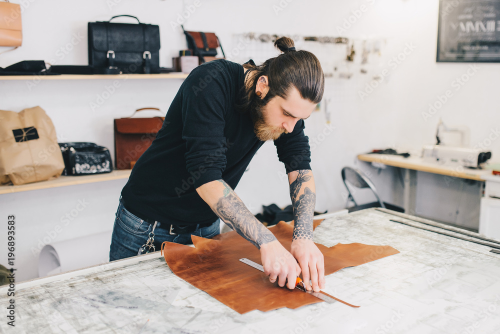 Professional Leather Worker working with leatherwork at his workplace Professional Leather Worker working with leatherwork at his workplace