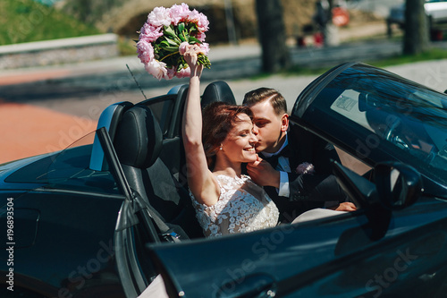 newlyweds kiss in the car in the summer