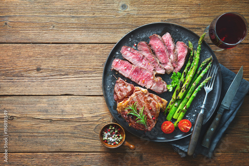 Roasted rib eye steak with green asparagus and wine photo