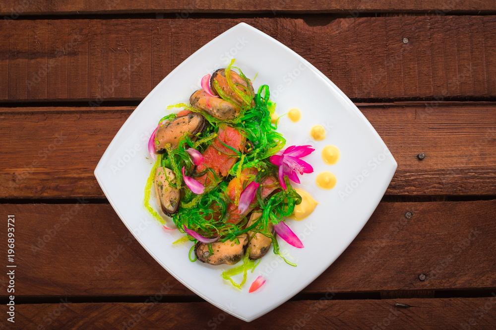 Salad with salmon, seaweed and mussels. Wooden rustic background. Top view