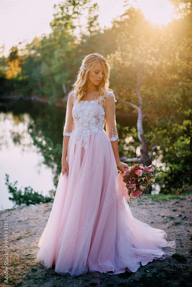 portrait of a young beautiful bride in the sun on a nature background