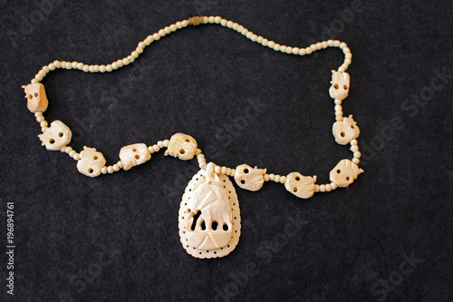 Necklace of white ivory on the black felt photo