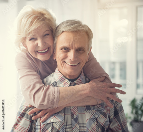 Happy old age. Portrait of hugging pensioners looking at camera with broad smile