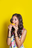 Fashion summer portrait funny indian girl with oranges over yellow background. Diet cincept