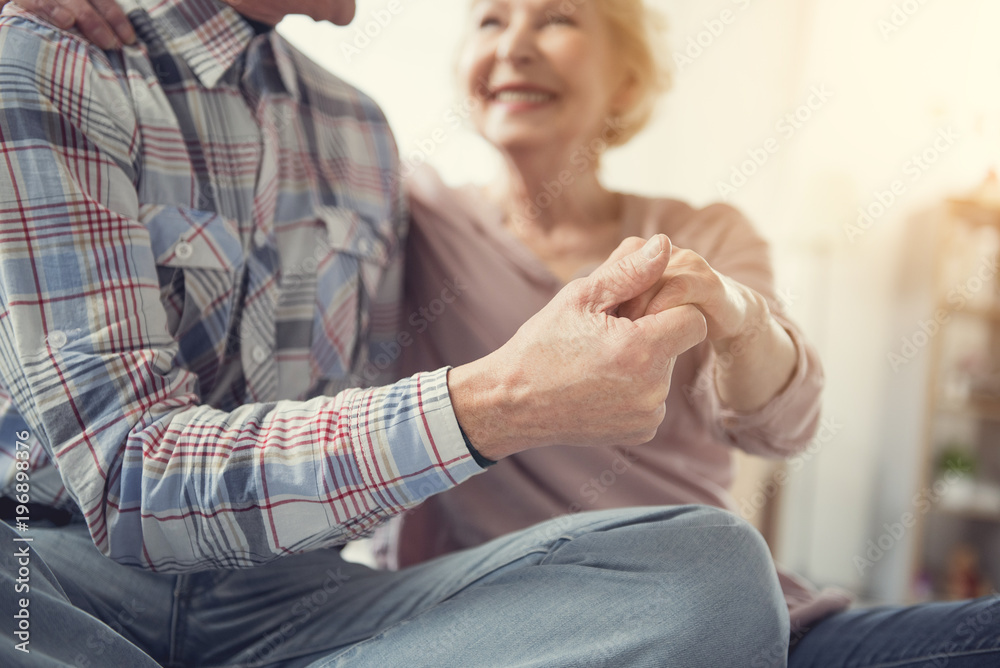 Endless love. Glad old male and female people keeping their hands together. Focus on arms Endless love. Glad old male and female people keeping their hands together. Focus on arms