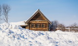 Village log cabin with carved shutters in the snow-covered village
