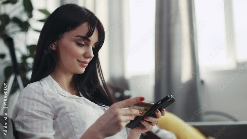 Portrait woman sitting on couch use phone and credit card at home beautiful telephone happy smartphone connection background business fashion hand happiness girl shopping money online pay attractive Portrait woman sitting on couch use phone and credit card at home beautiful telephone happy smartphone connection background business fashion hand happiness girl shopping money online pay attractive
