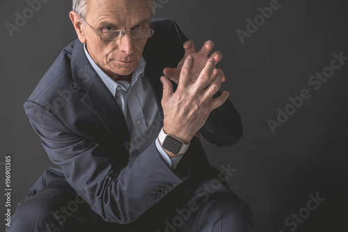 Old businessman expressing anger while gesticulating hands. Wrathful pensioner concept. Copy space