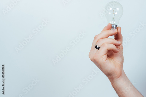 Man’s hand holding a light bulb