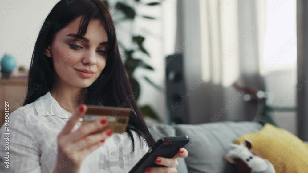Charming woman sitting on couch use phone and credit card at home beautiful telephone happy smartphone connection background business fashion hand happiness girl shopping money online pay attractive Charming woman sitting on couch use phone and credit card at home beautiful telephone happy smartphone connection background business fashion hand happiness girl shopping money online pay attractive