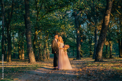 portrait of happy newlyweds during a walk in the forest