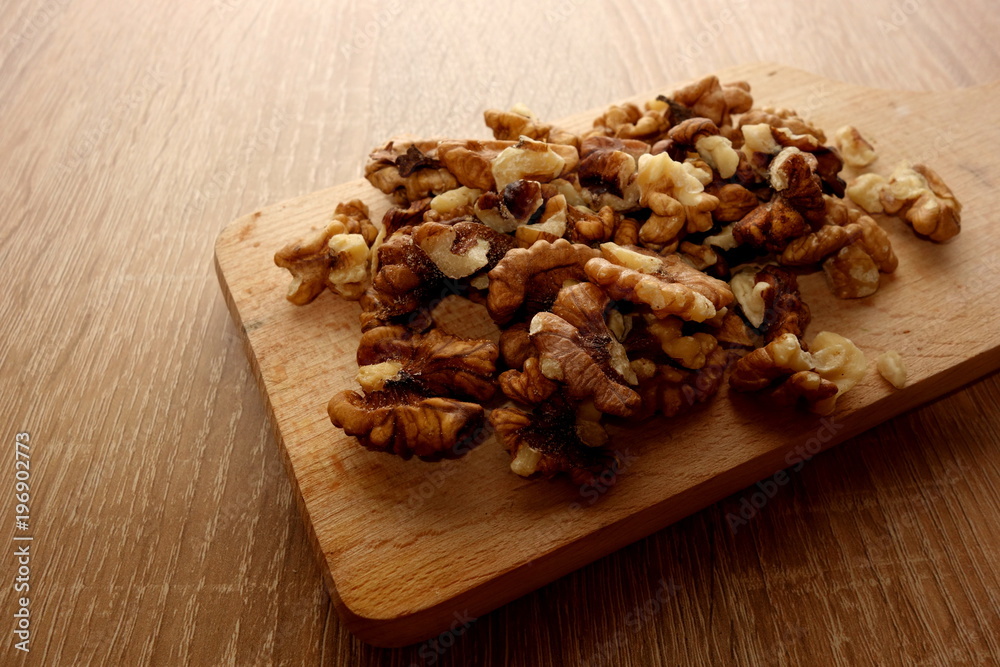 Fresh walnuts on wooden cutting board, close-up