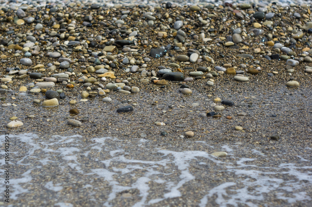 pebble stones on the sea beach, the rolling waves of the sea with foam pebble stones on the sea beach, the rolling waves of the sea with foam