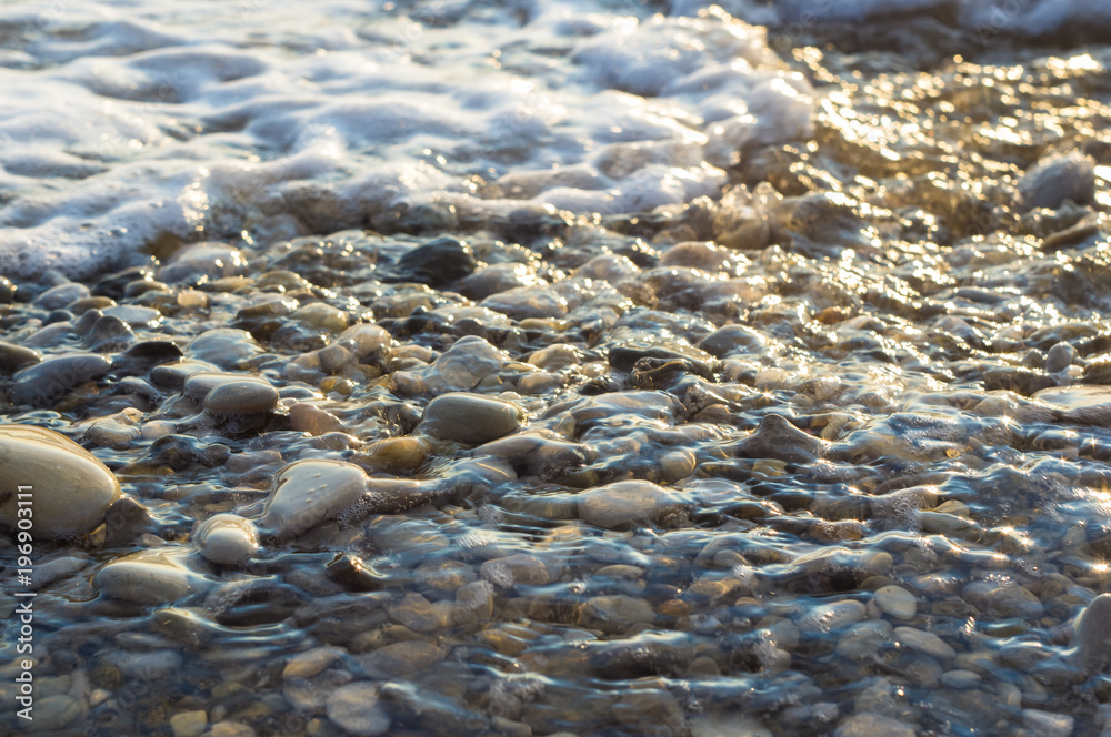 pebble stones on the sea beach, the rolling waves of the sea with foam pebble stones on the sea beach, the rolling waves of the sea with foam