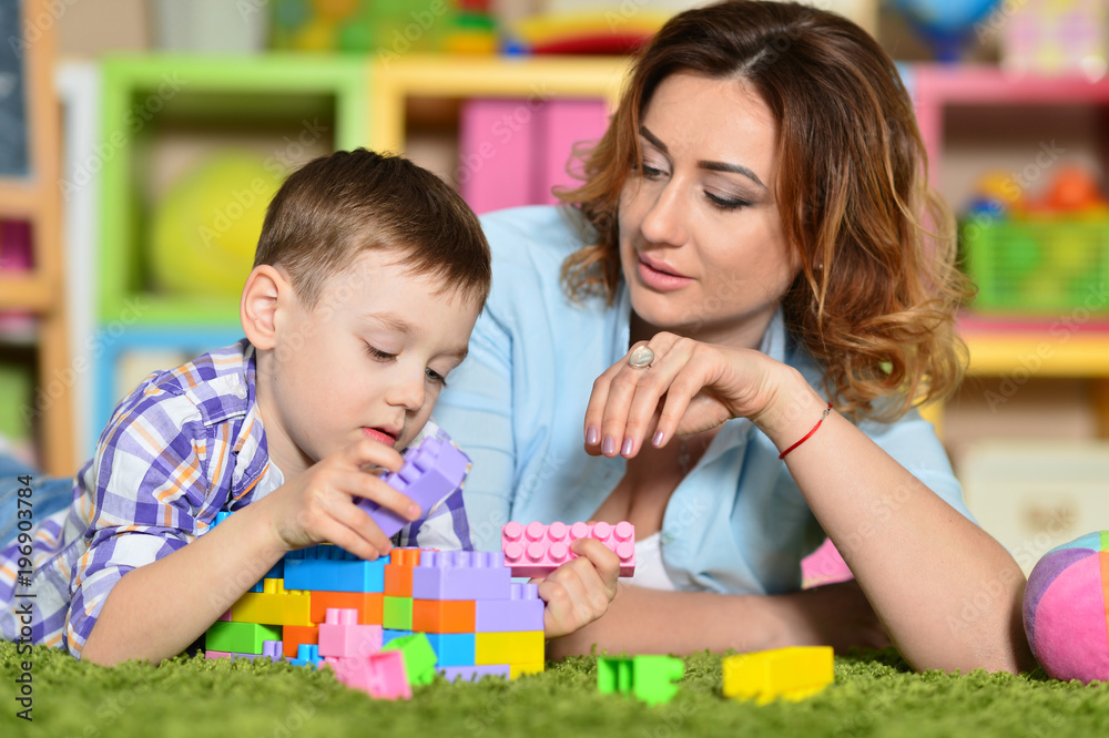 Fototapeta premium Young mother playing with son