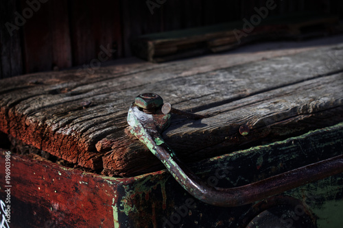 old red and green piece of vintage aged wood with a nail