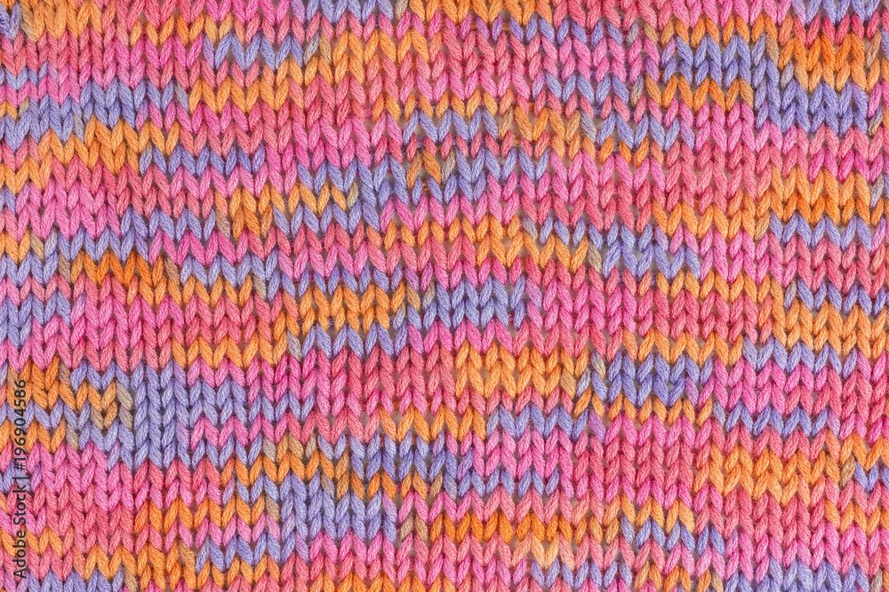 background of multicolored knitted fabric in pink, orange and lilac