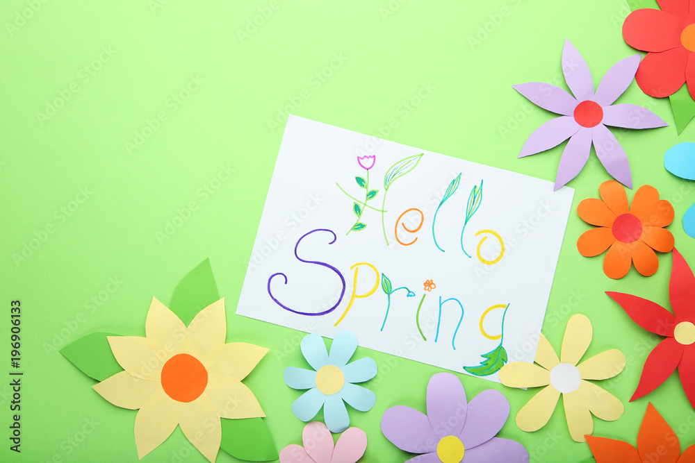 Inscription Hello Spring with paper flowers on green background