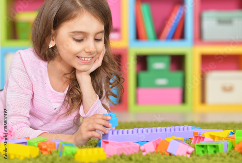 Cute girl playing with plastic blocks